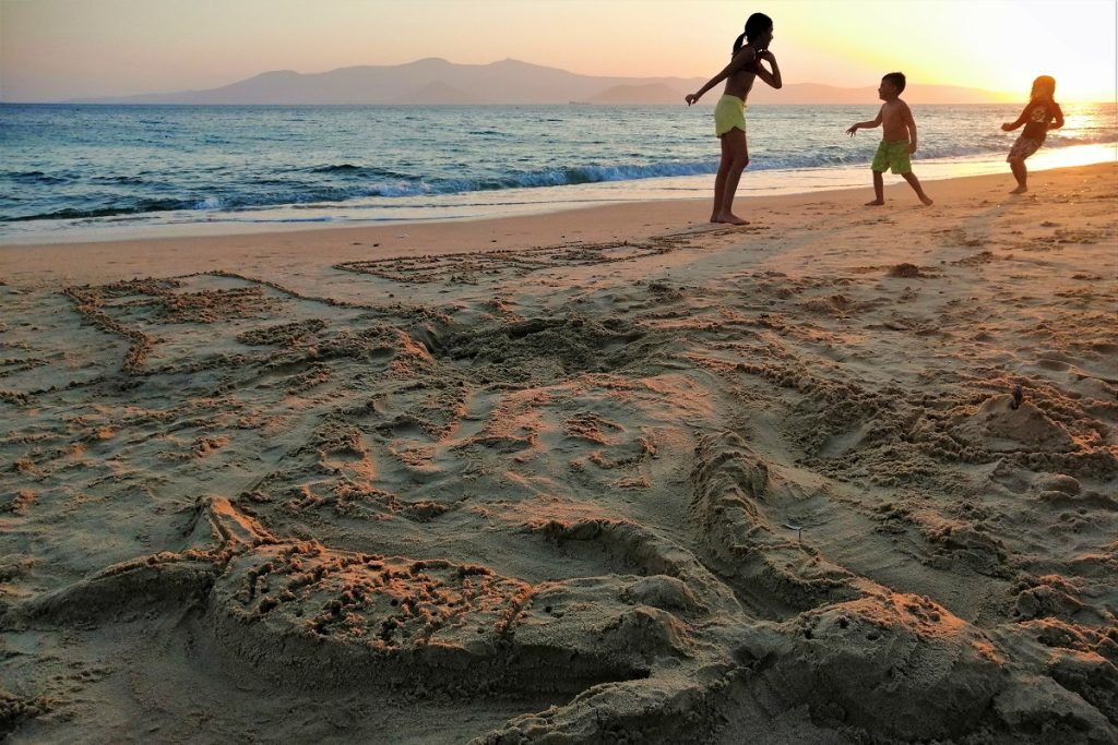 Kids enjoying a Beach in Greece, as the sunsets. 